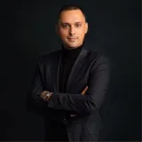 A man in a black suit posing for a picture.